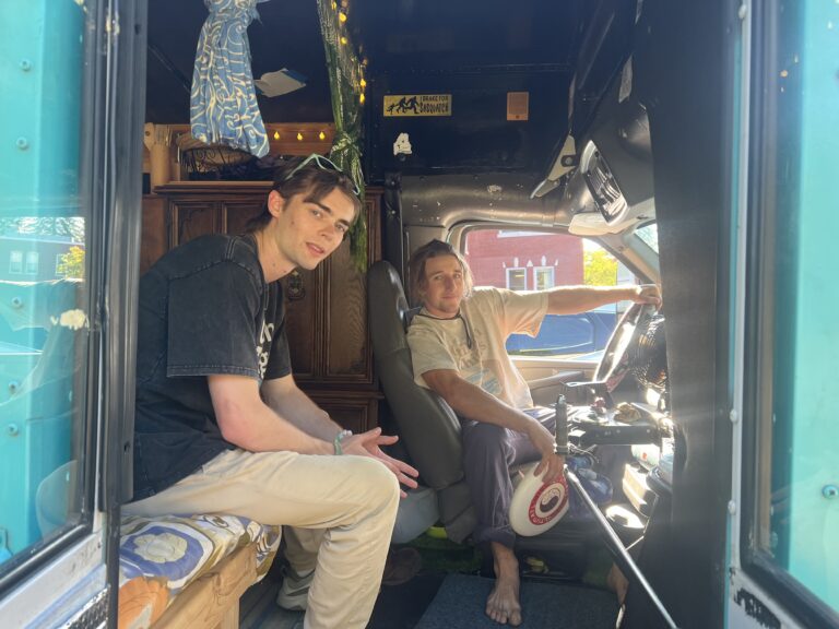 Cash Cassidy and Tyler Brown pose for a photo in the entryway of the bus from 'Childish Things.'